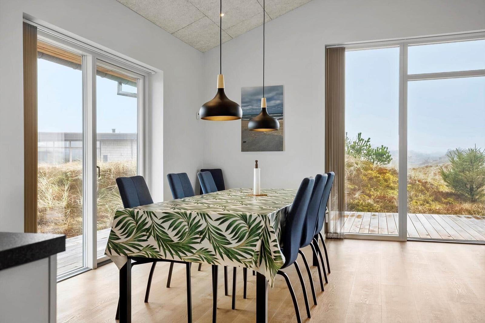 Esszimmer mit Tisch, Stühlen und Blick auf die Außenterrasse.