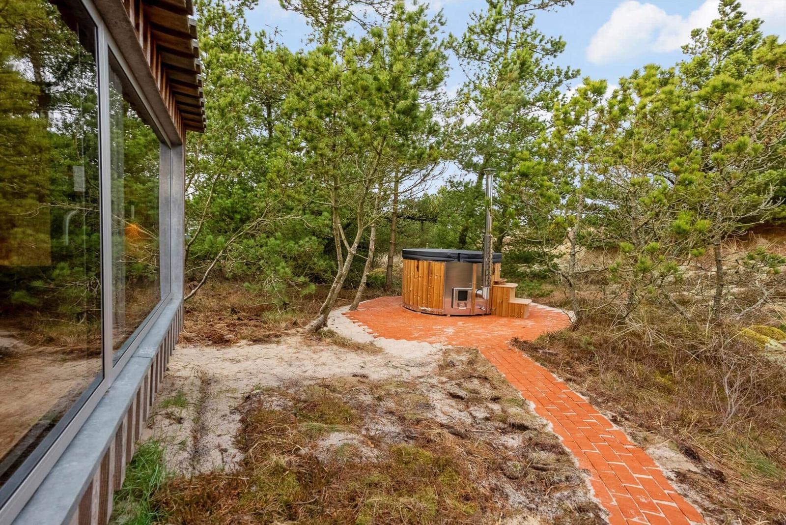 Haus mit Holzsauna auf Terrasse im Wald