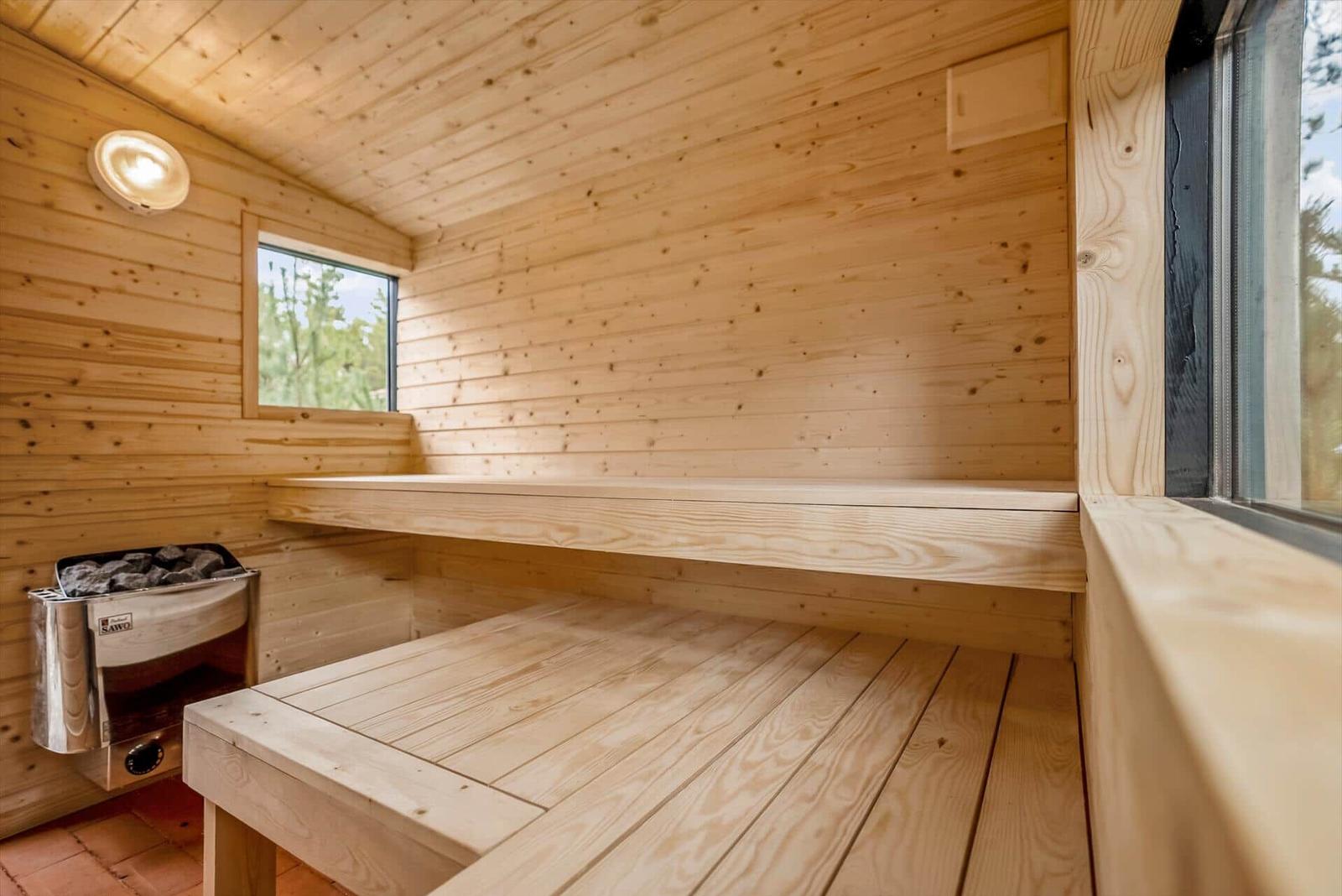 Sauna mit Holzbank, Heizung und Fenstern.
