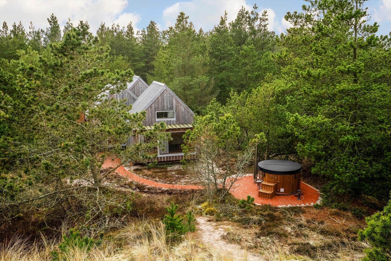 Hütte im Wald mit Whirlpool auf Terrasse