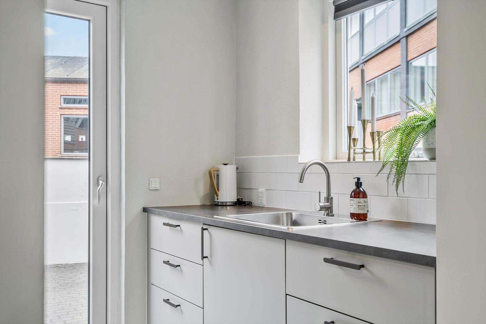 Küche mit Waschbecken, Spüle und Fensterblick.