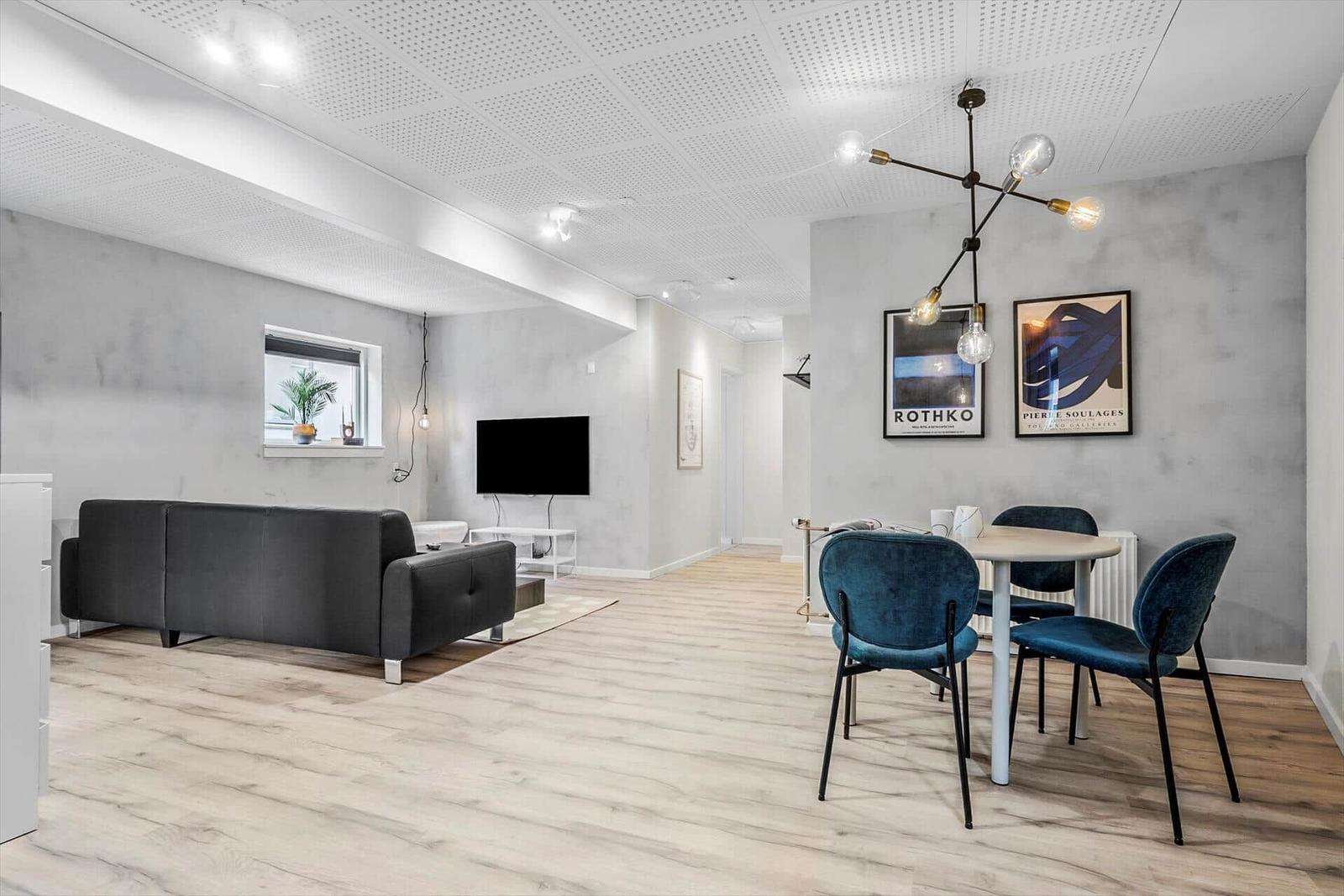 Wohn- und Essbereich mit Sofa, Esstisch und Wandbildern.