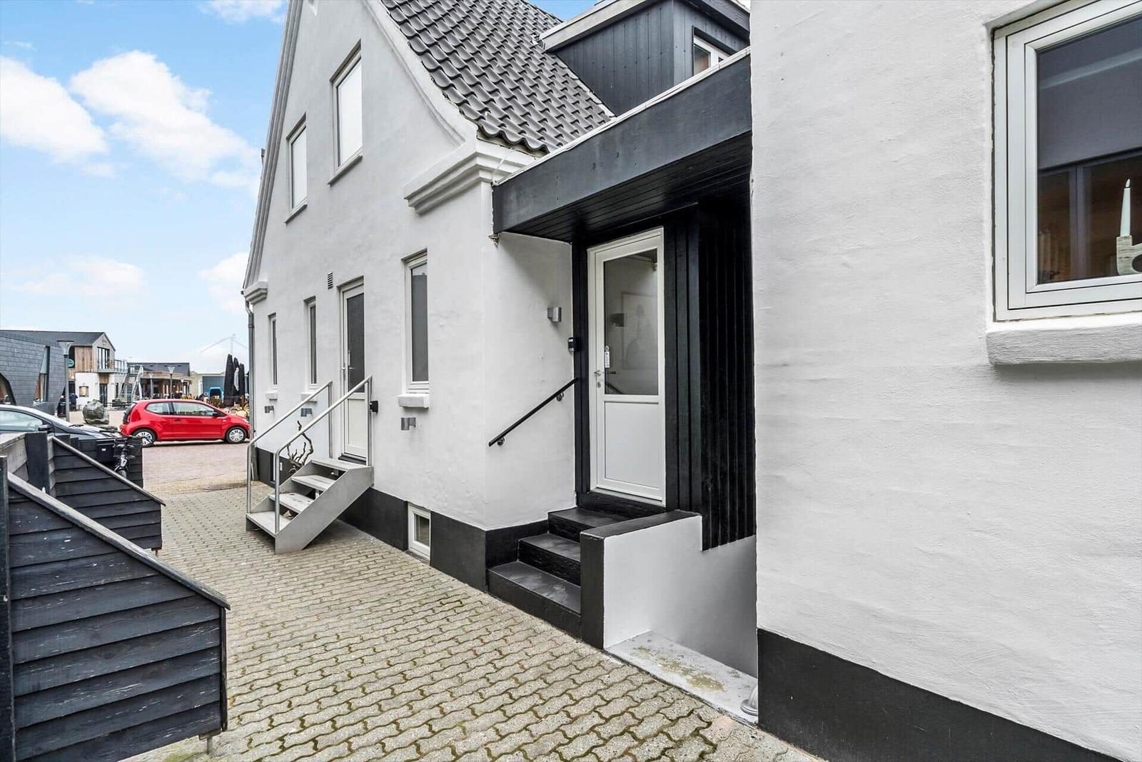 Weiße Fassade mit schwarzen Akzenten und Eingangstreppe