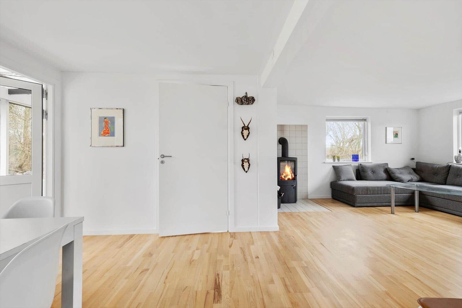 Wohnzimmer mit Holzboden, Sofa, Kamin und Wanddekoration.
