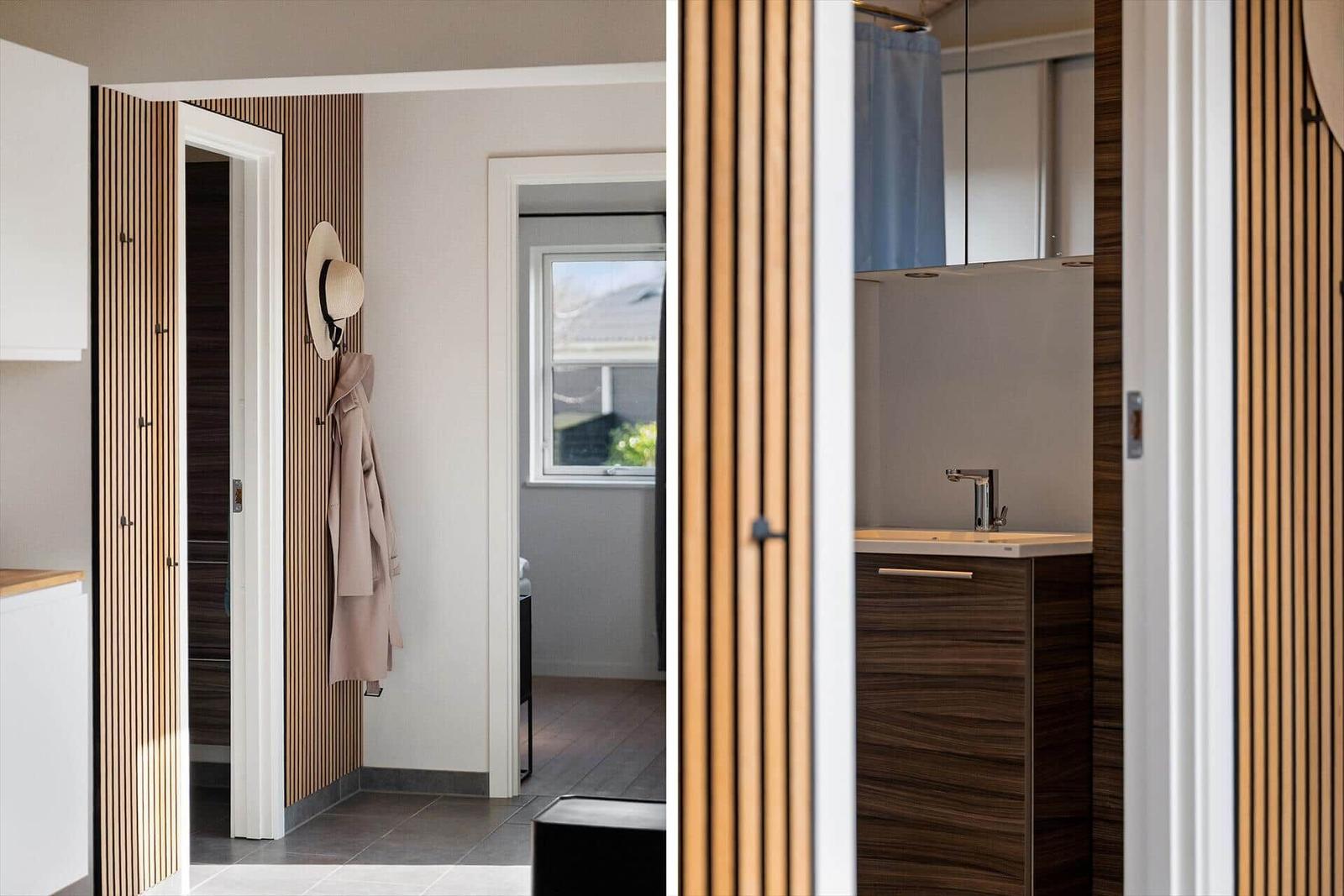 Haus mit modernem Badezimmer und Eingangsbereich mit Holzverkleidung und Kleidungsständer.