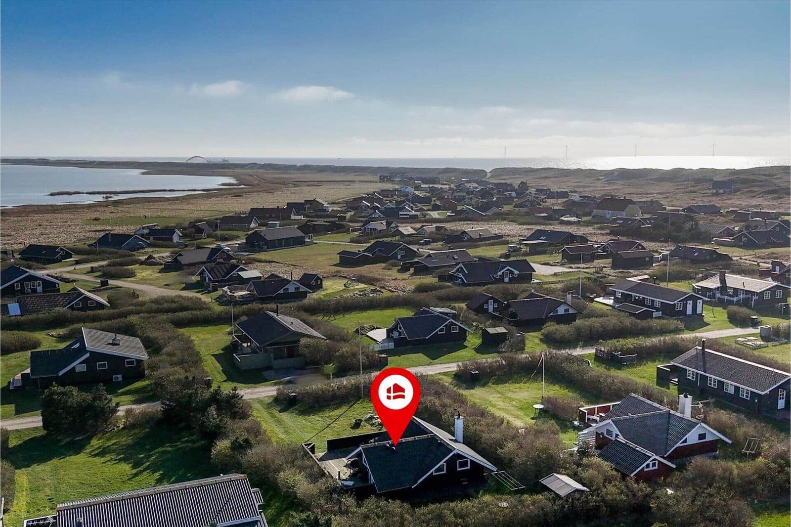 Aerial view of a coastal village with houses and a lake.