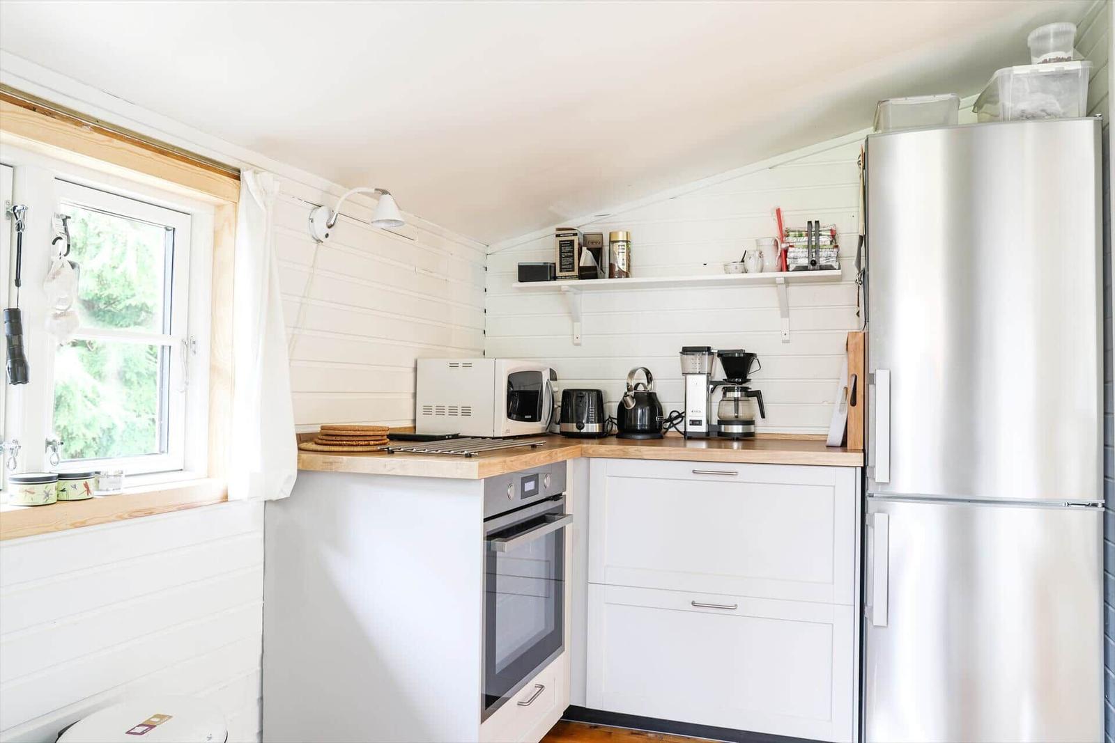 Küche mit Kühlschrank, Herd und Fenster