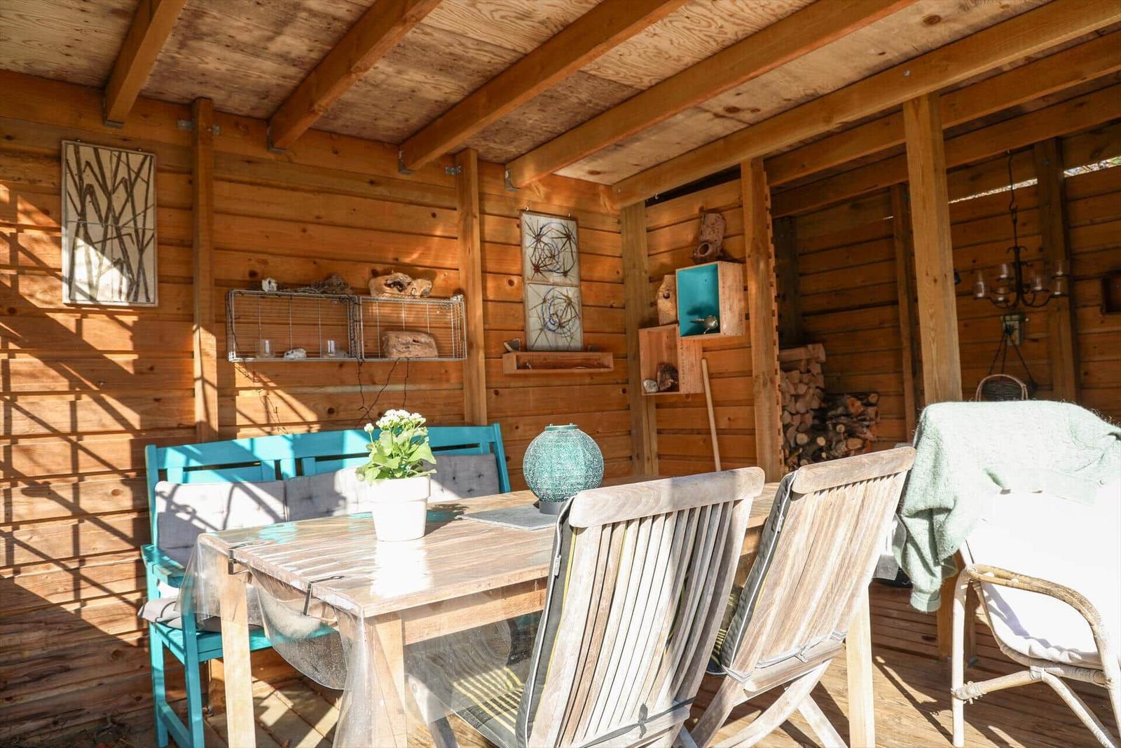 Holzterrasse mit Tisch, Stühlen und Dekoration.