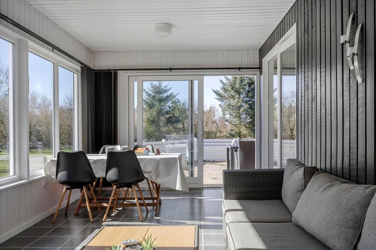Sitzbereich mit Sofa, Esstisch und Blick auf die Terrasse.