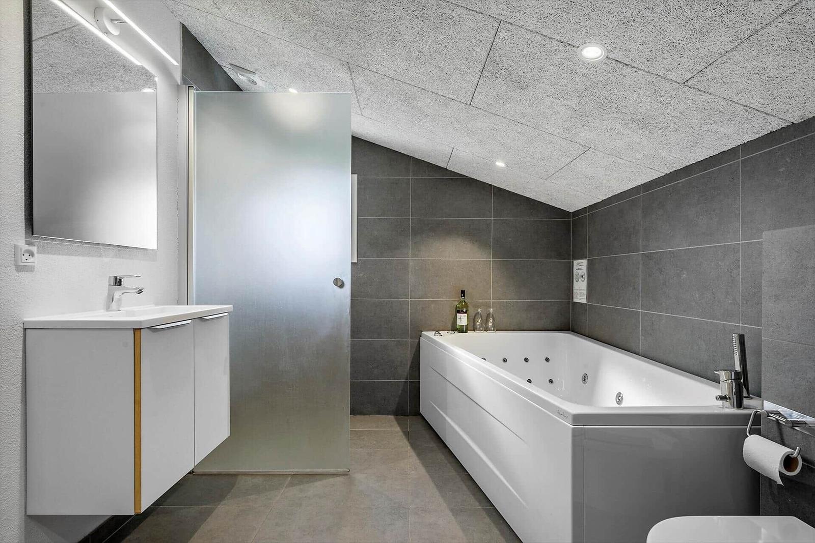 Dusche, Badewanne und Waschbecken in moderner Badezimmerausstattung.