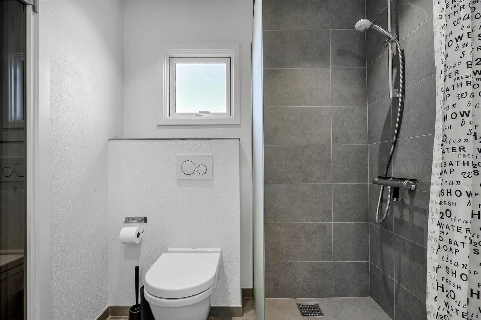 Bad mit Dusche, Toilette und kleinem Fenster