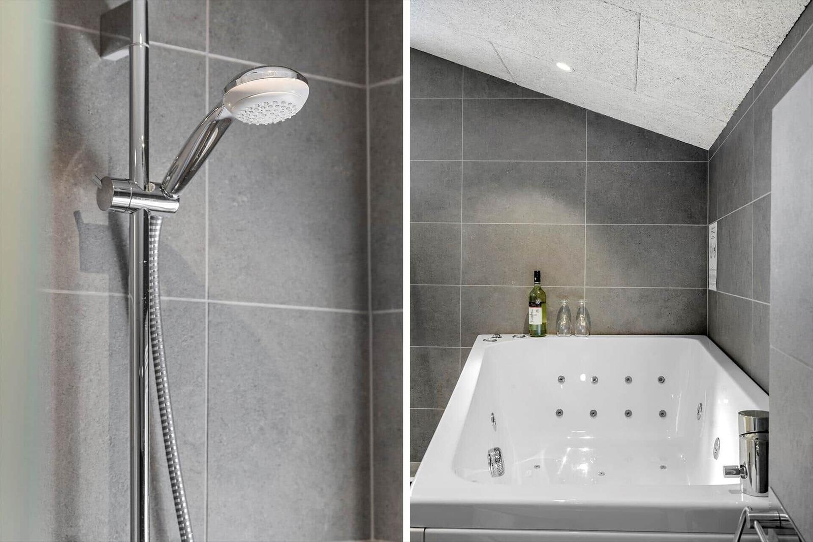 Dusche mit Handbrause und Whirlpool-Bad mit Flasche und Gläsern
