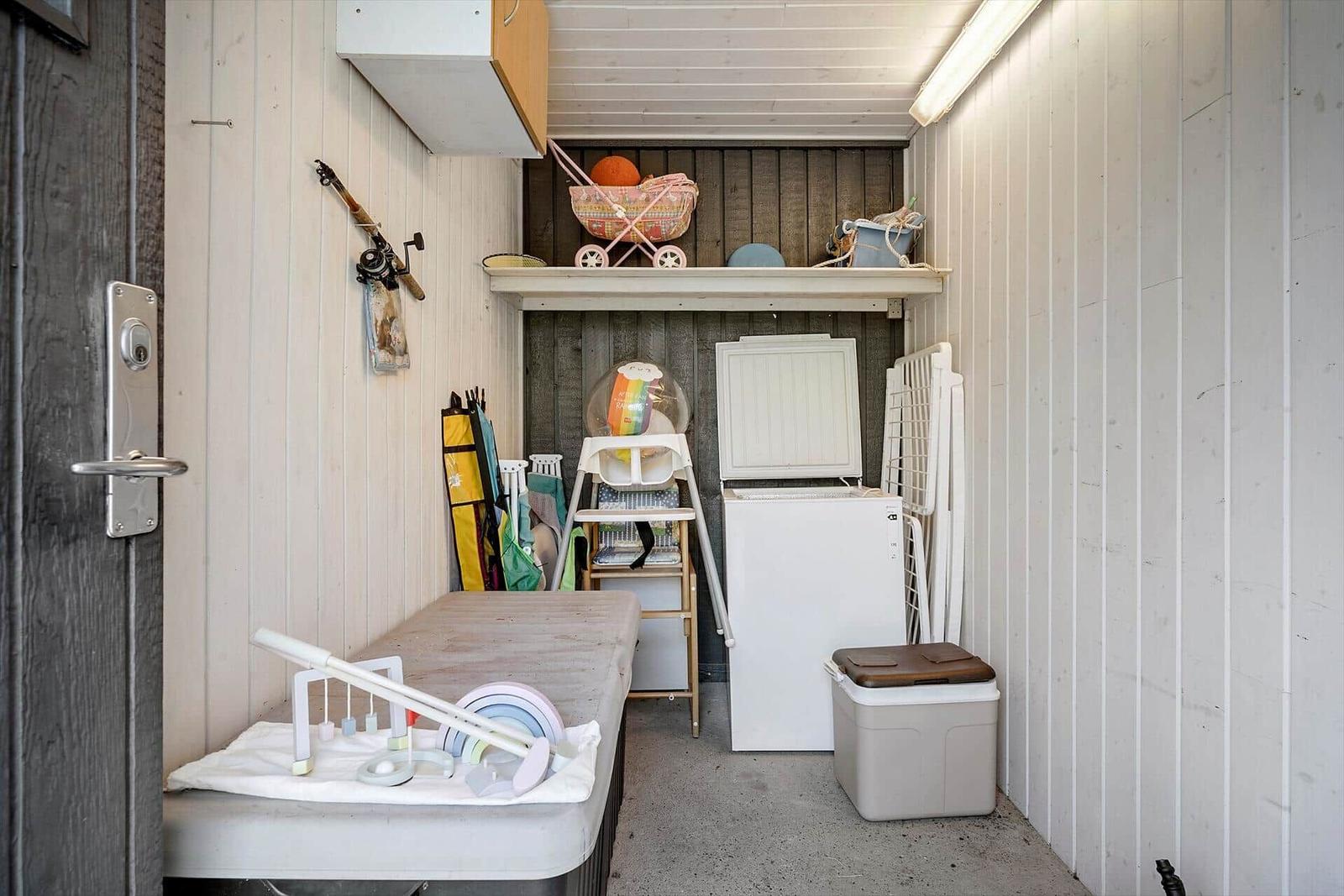 Kleines Lager mit Waschmaschine, Kinderbett und Spielzeug.