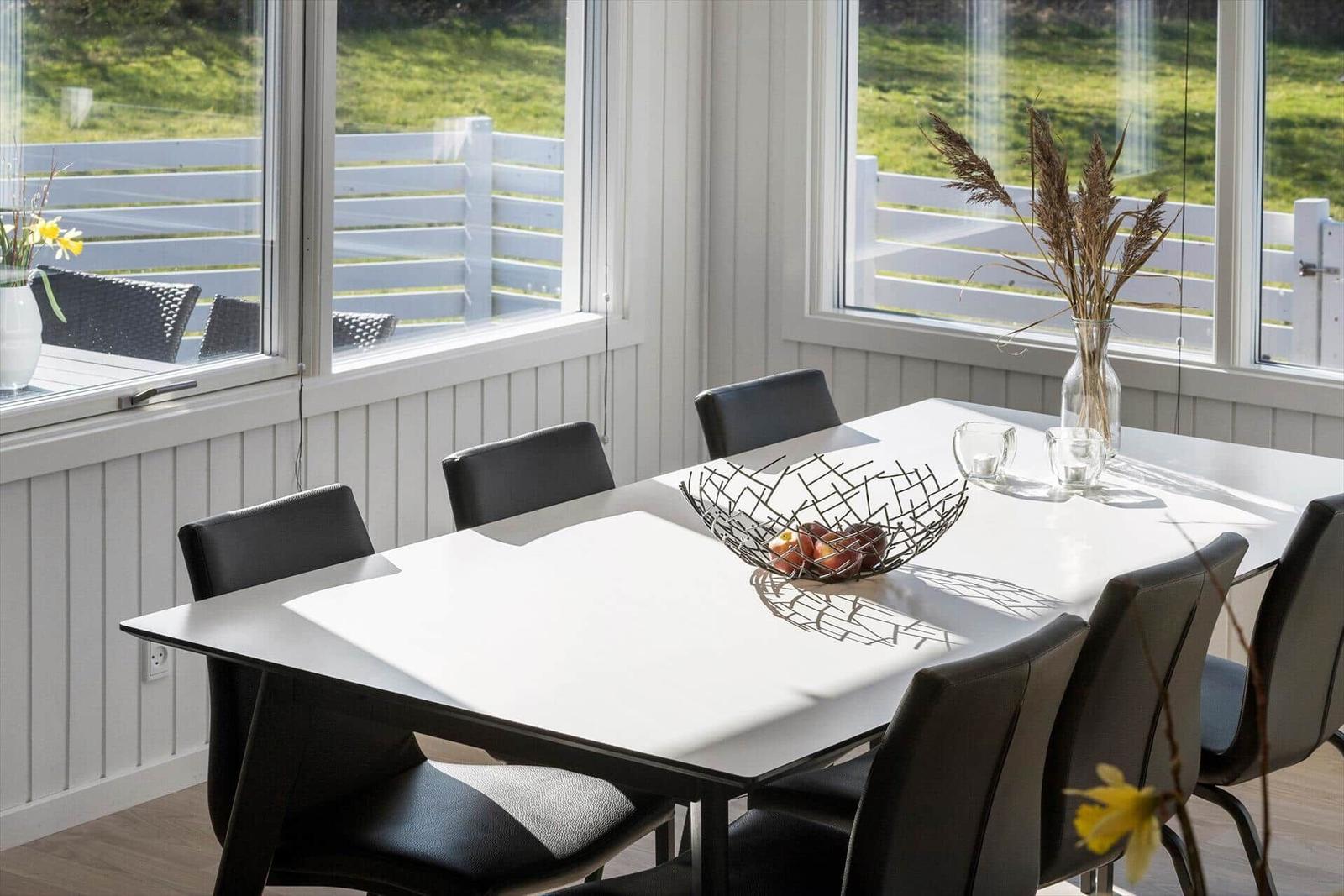 Esstisch mit sechs Stühlen, Fensterblick auf Garten und Terrasse.