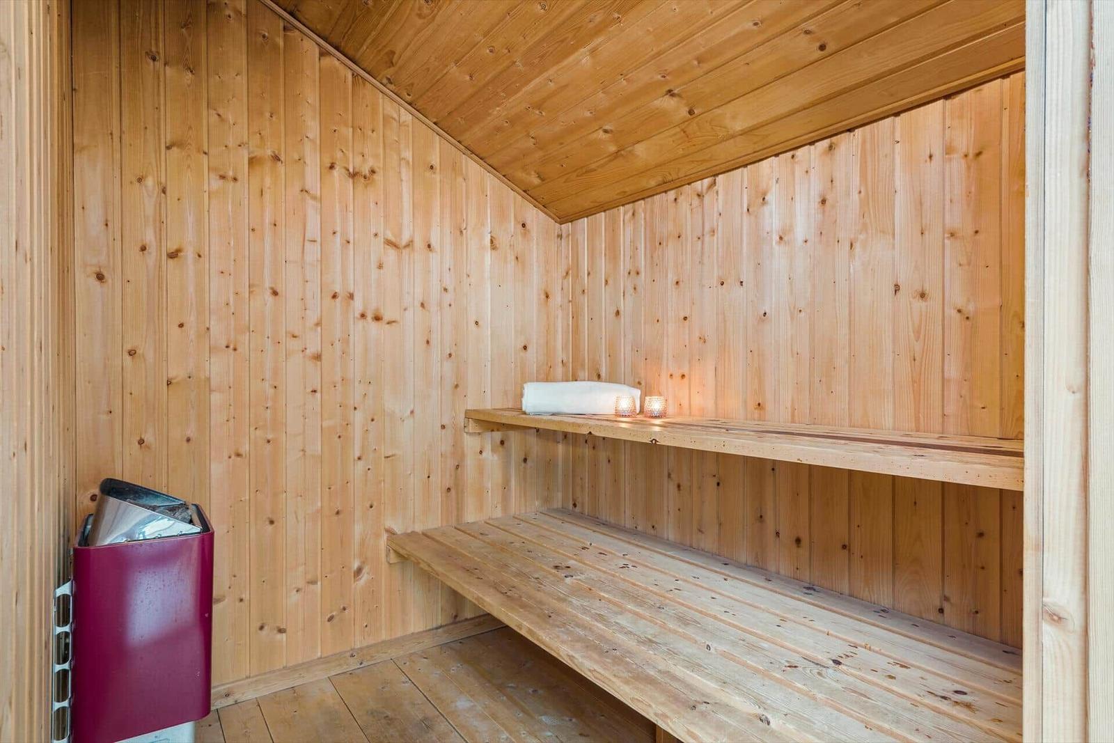 Holzsauna mit Bank, Handtuch und Kerze