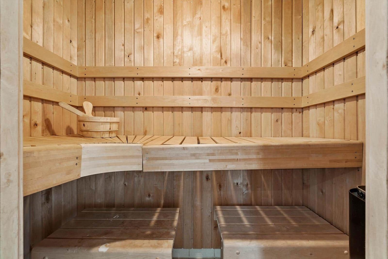 Holzsauna mit Sitzbänken und Eimer. Holzwände und -bänke.