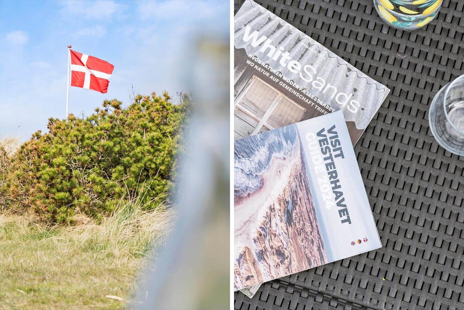 Dänische Flagge weht am Strand. Rechts: Reiseführer auf Tisch.