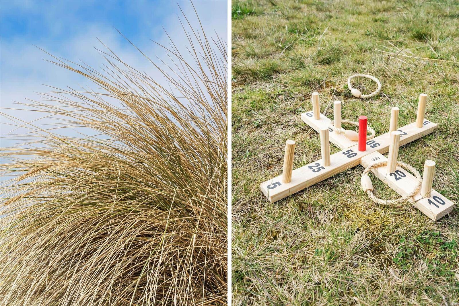 Hochstehende Gräser im Wind und ein Holzspiel auf Gras.
