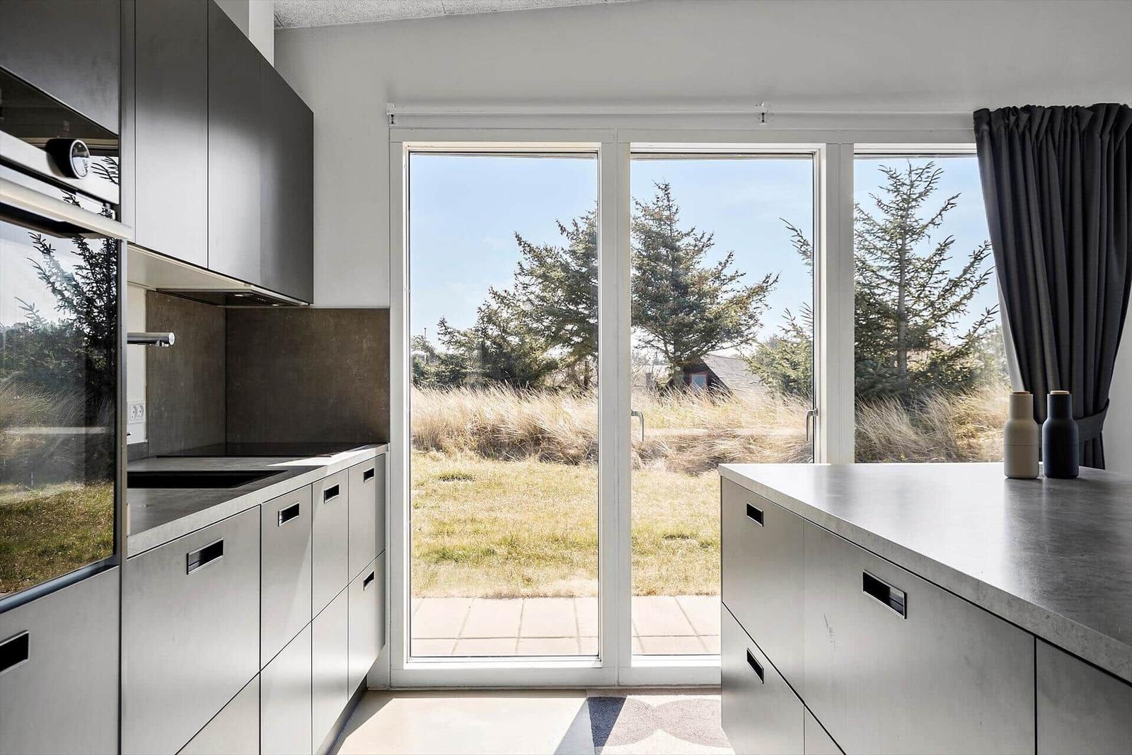 Moderne Küche mit Blick auf Grünfläche und Bäume