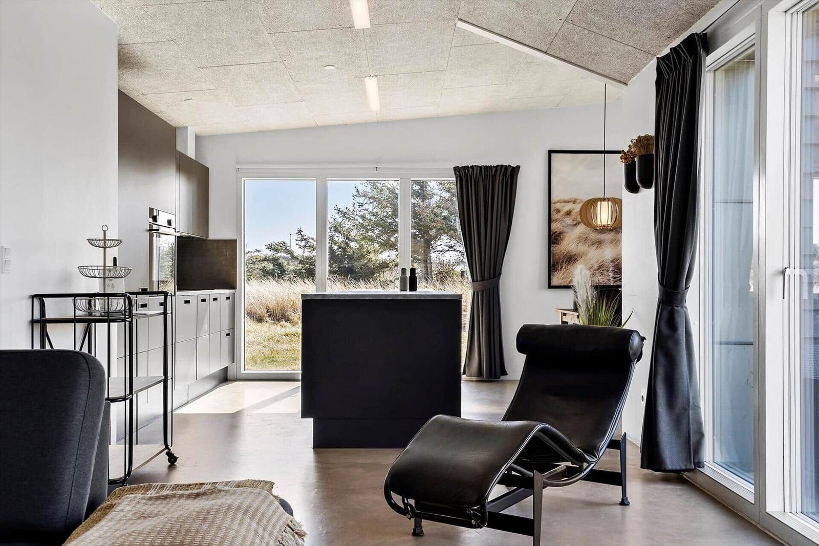 Moderne Küche mit Essbereich und großem Fensterblick auf Grünflächen.