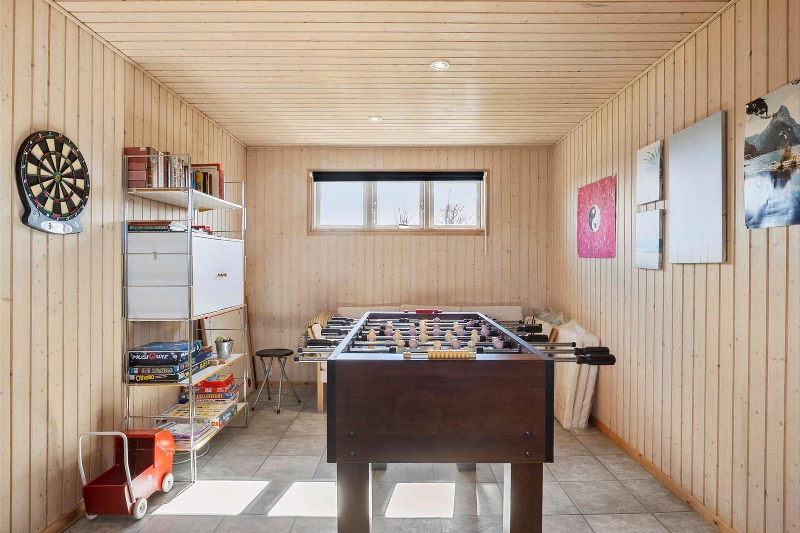 Raum mit Tischfußball, Dart und Brettspielen an Regalen
