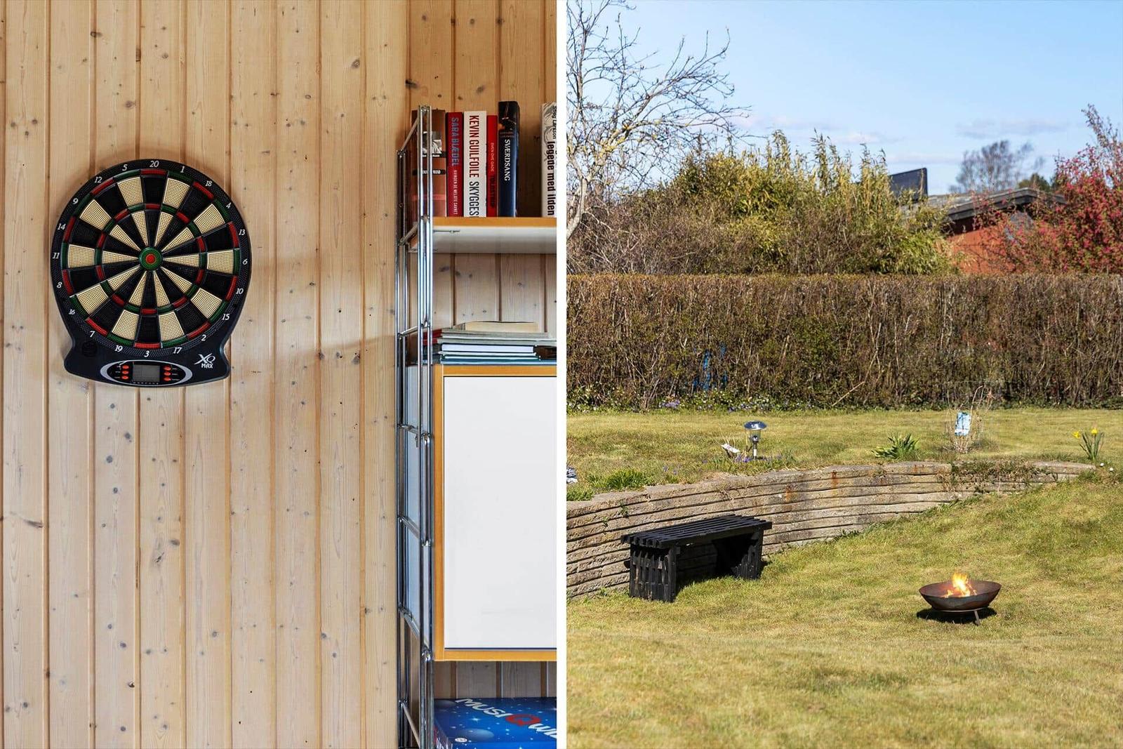 Dartboard an Holzwand und Bücherregal. Außenbereich mit Feuerkorb und Bank.