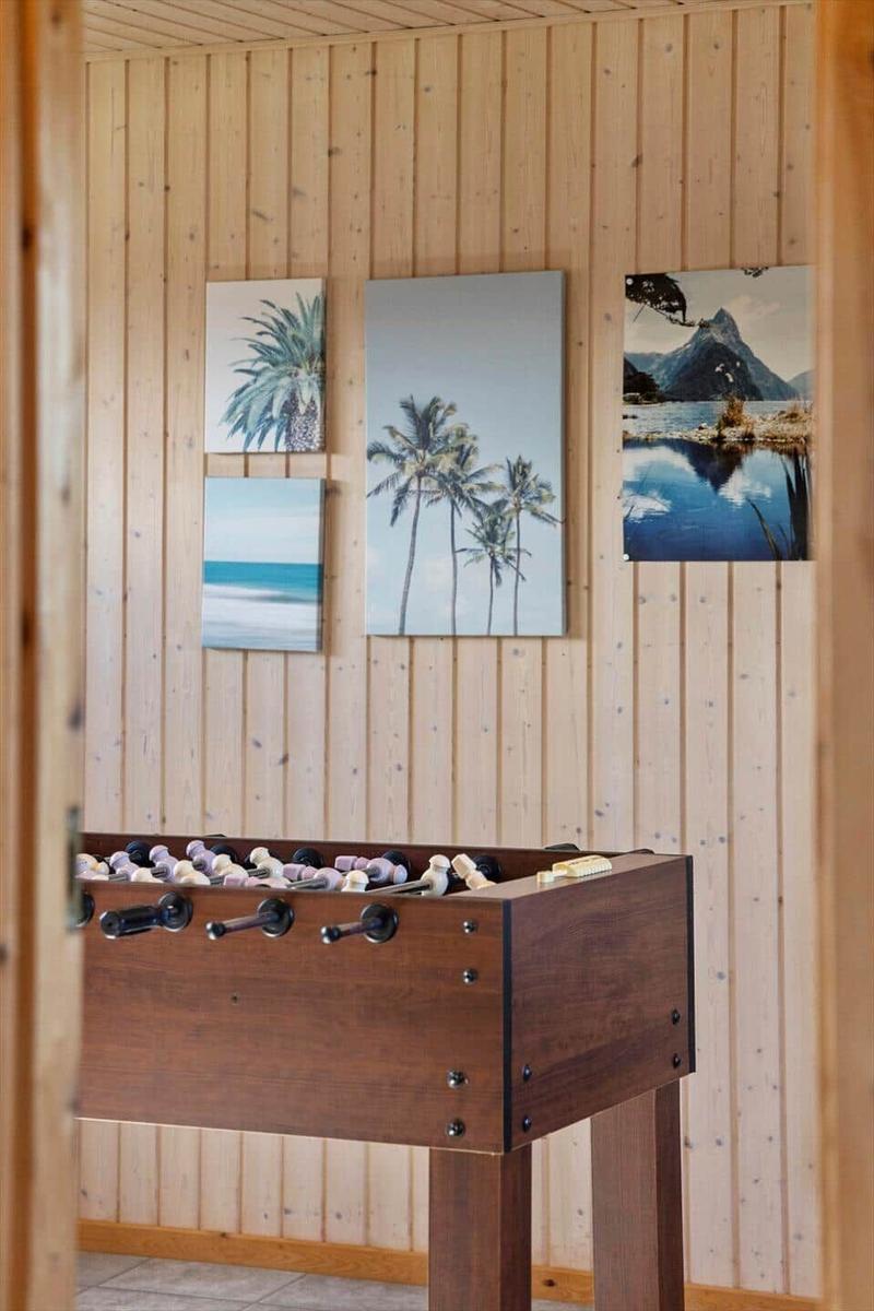 Fußballtisch in einem Raum mit Holzwand und Wandbildern.