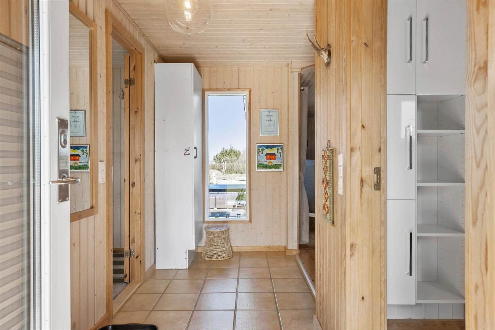 Haus mit Holzwänden, weißen Schränken und Blick auf Pool.