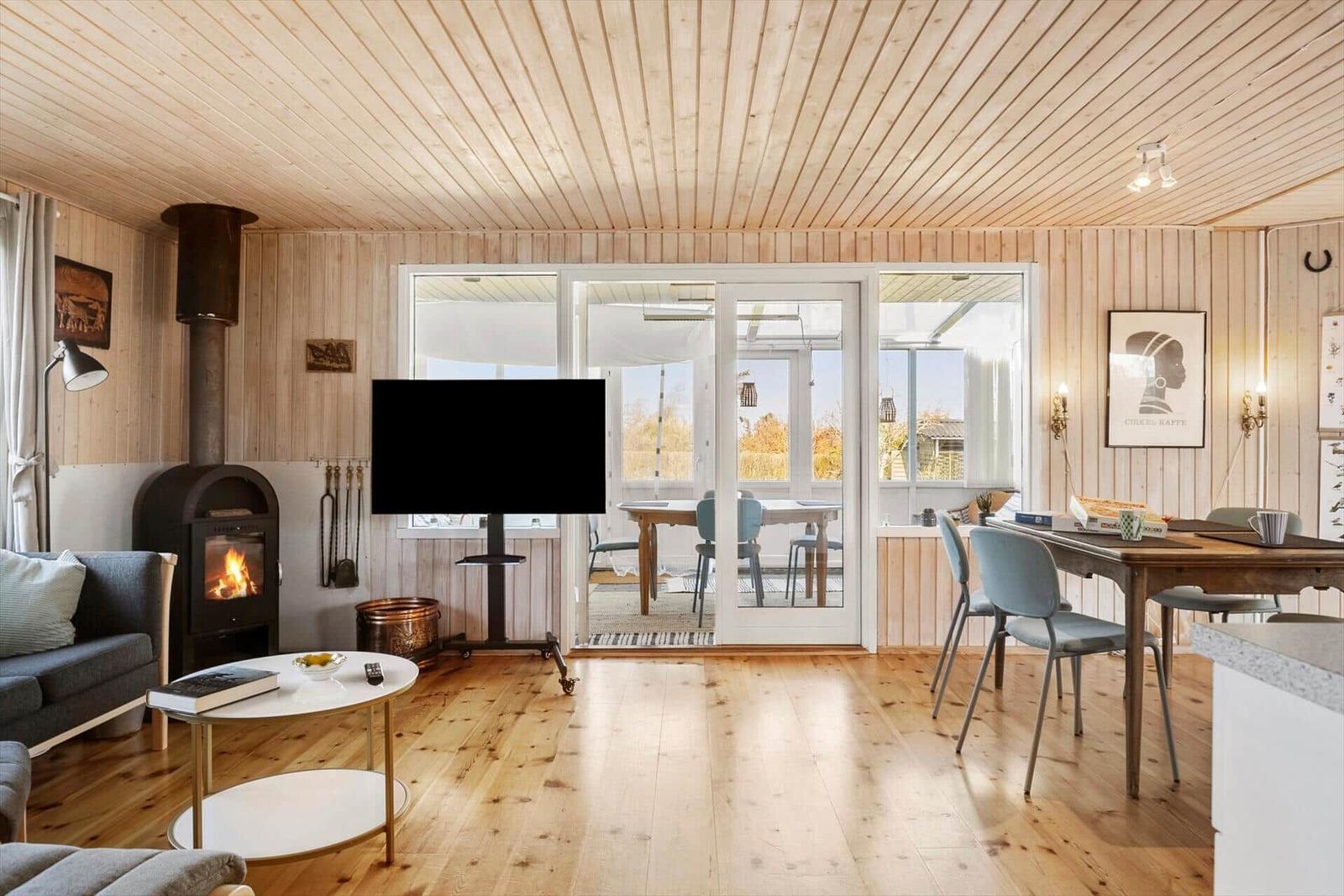 Wohn- und Essbereich mit Kamin, TV und Terrasse.