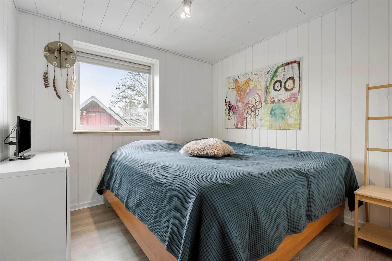 Bedroom with bed, window, and wall art.