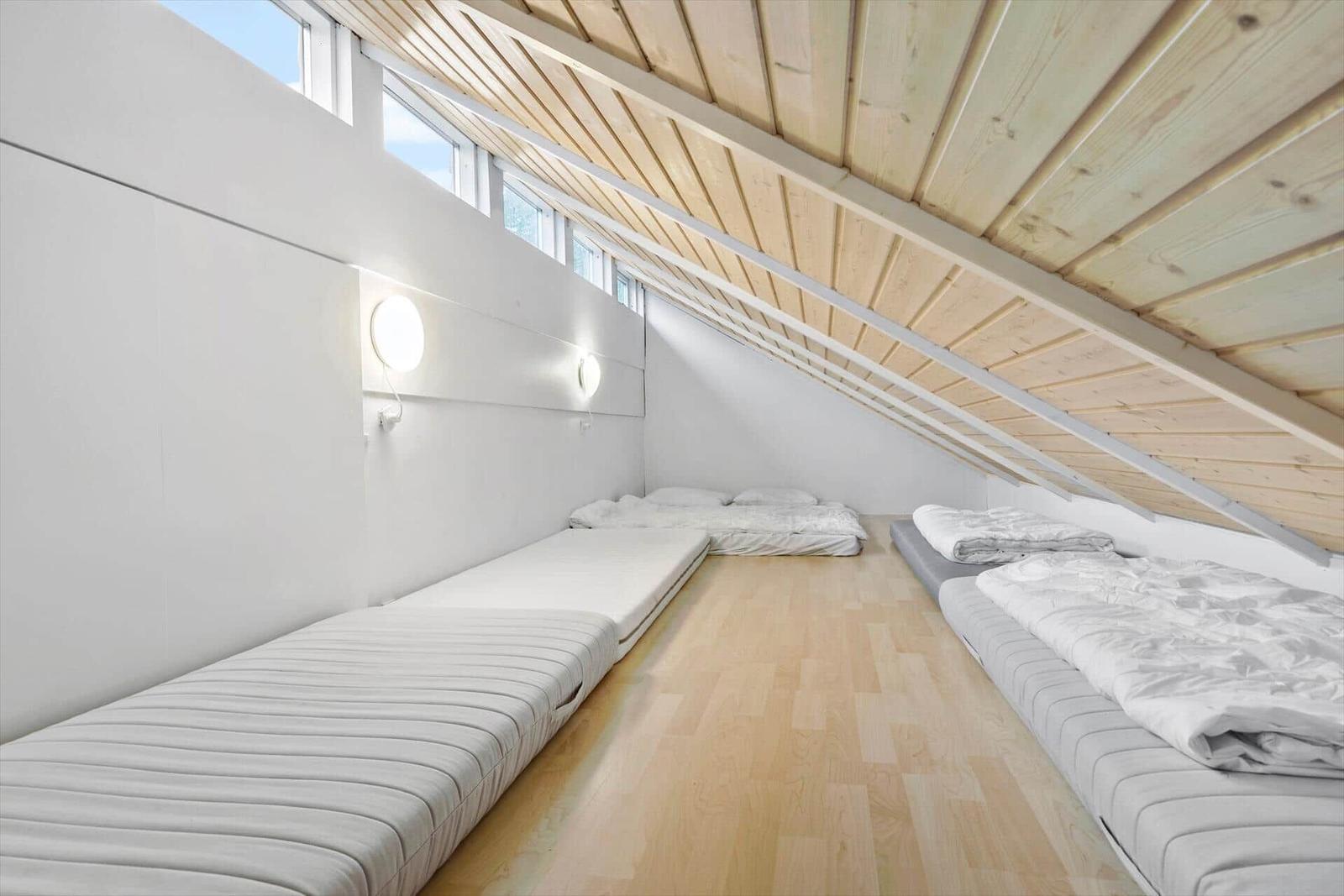 Dachgeschosszimmer mit Matratzen und Holzdecke
