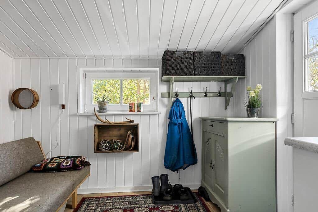 Eingangsbereich mit Garderobe, Schuhschrank und Fenster mit Blick auf Garten.