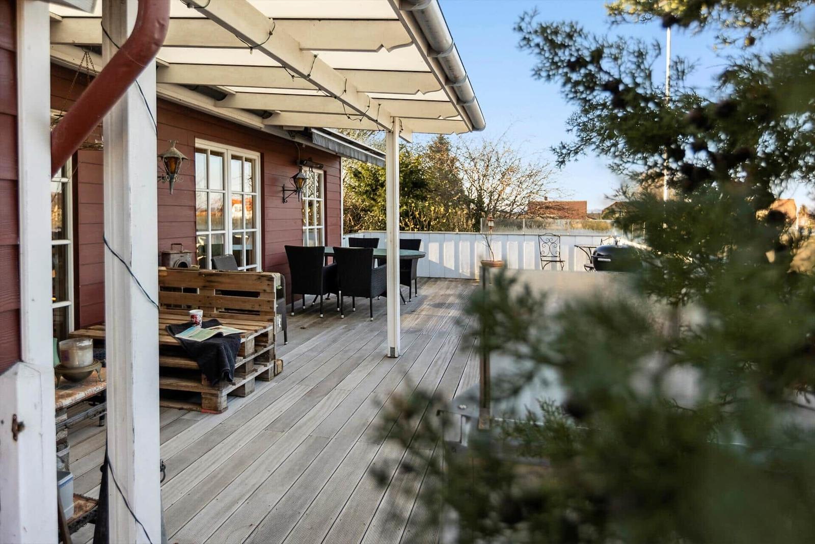 Terrasse mit Sitzgelegenheiten und Grillplatz im Freien.