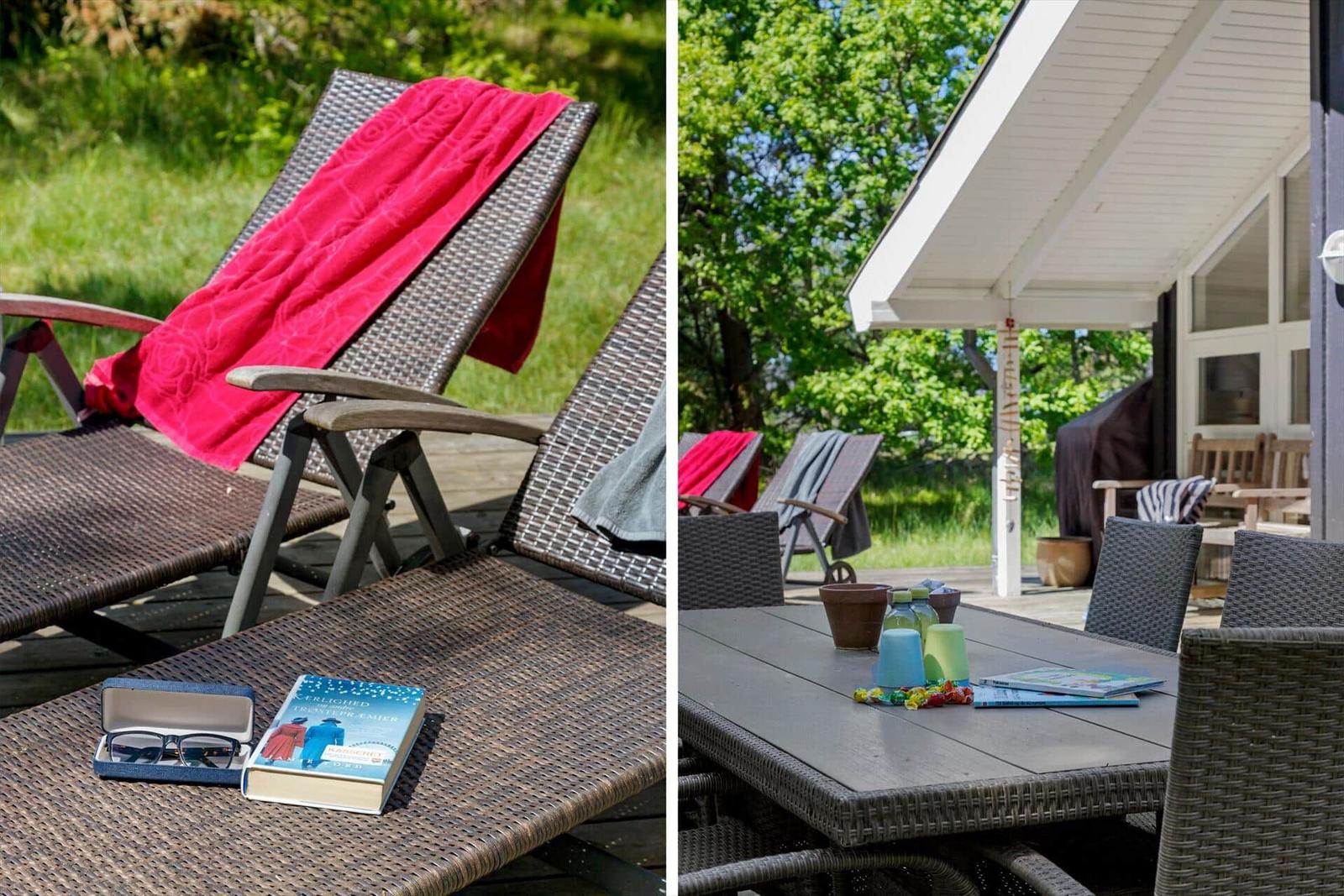Terrasse mit Liegestühlen, Tisch und Gartenmöbeln. Rote Decke und Buch liegen bereit.