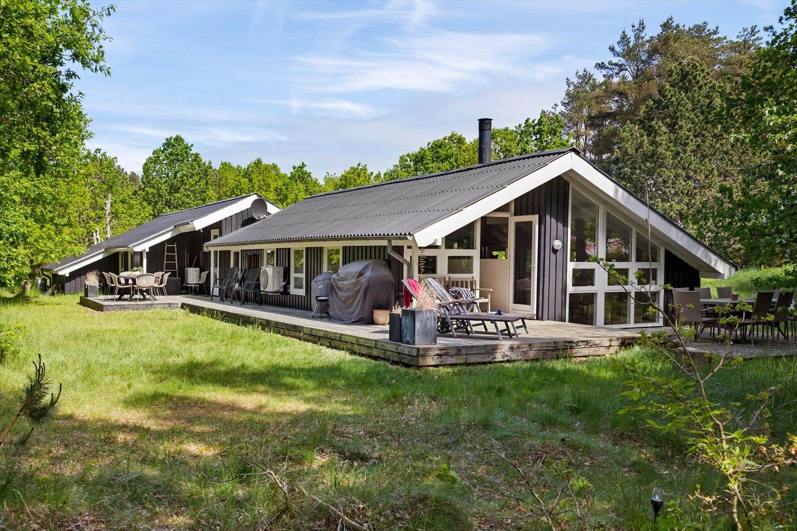 Moderne Holzhütte mit großem Garten und Terrasse. Außenbereich mit Grill und Sitzgelegenheiten.