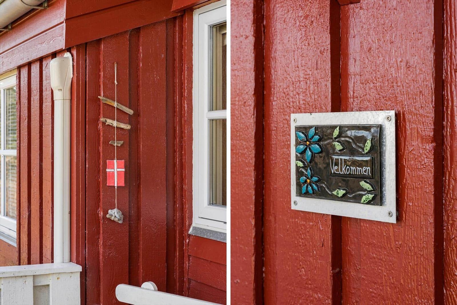 Rotes Holzhaus mit Willkommensschild und deutschem Fenster
