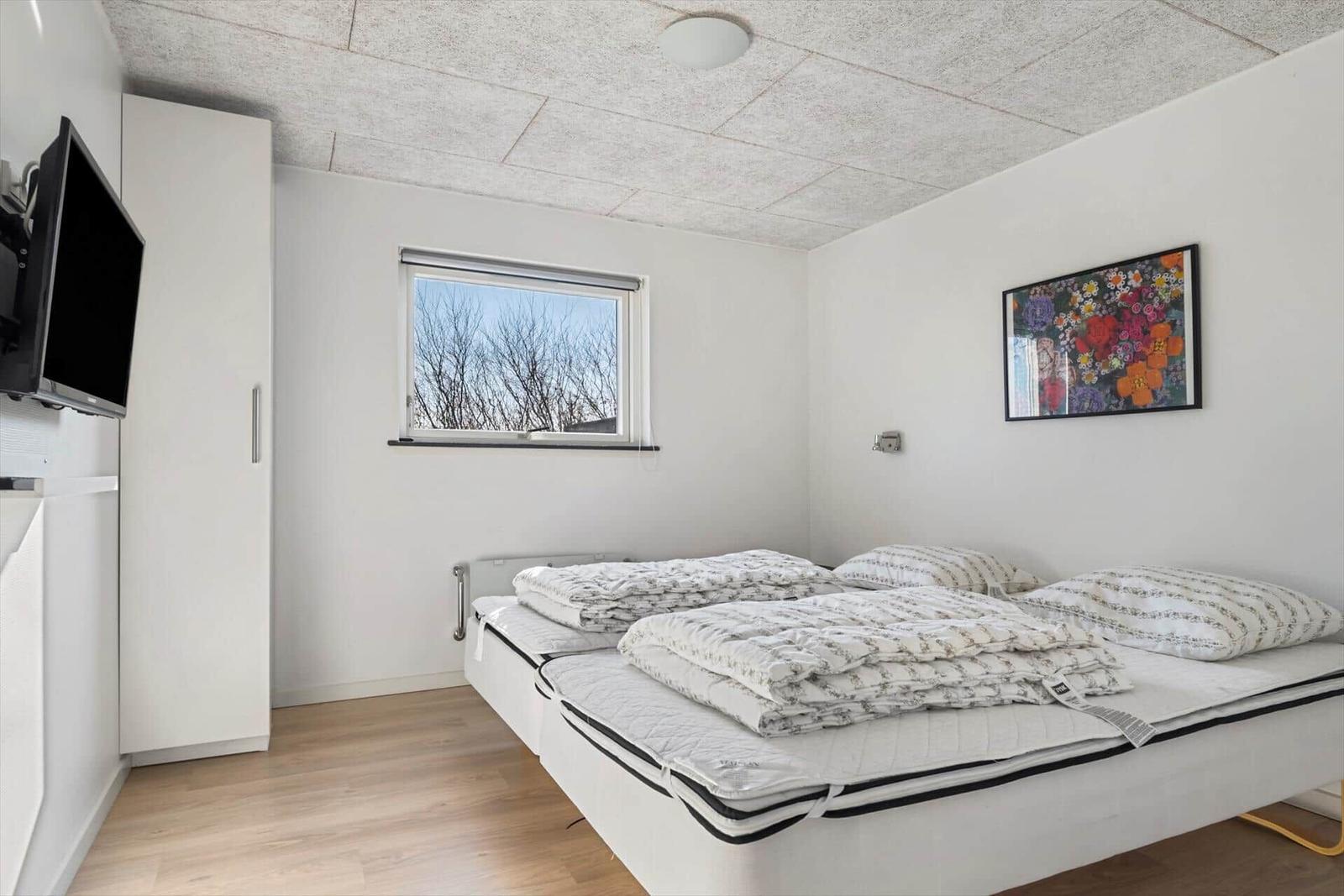 Bedroom with bed, window, and wall art.