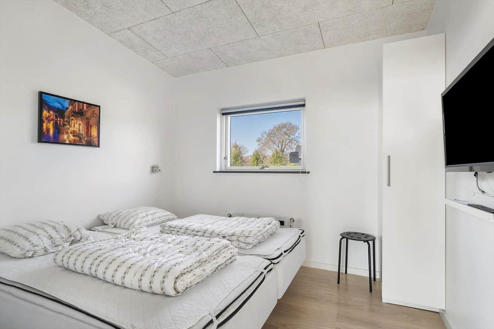 Bedroom with double bed, window, and TV.