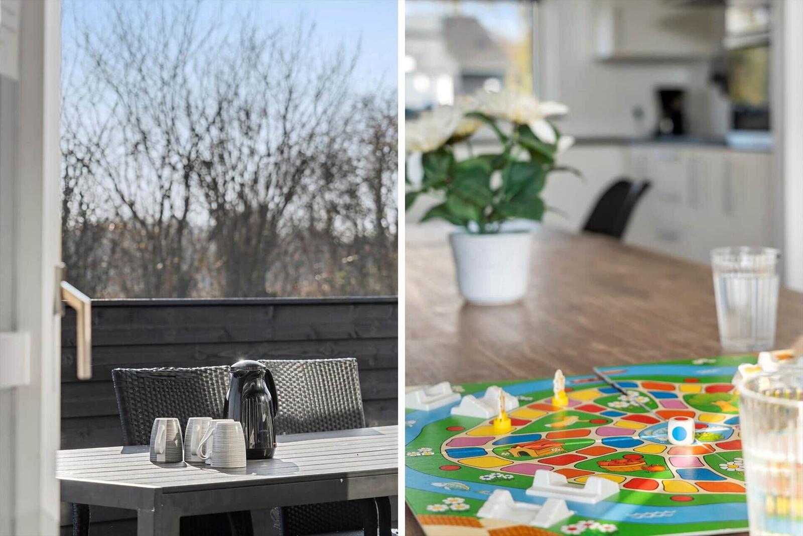 Terrace with table, chairs, and coffee pot. Inside, a game lies on the table.