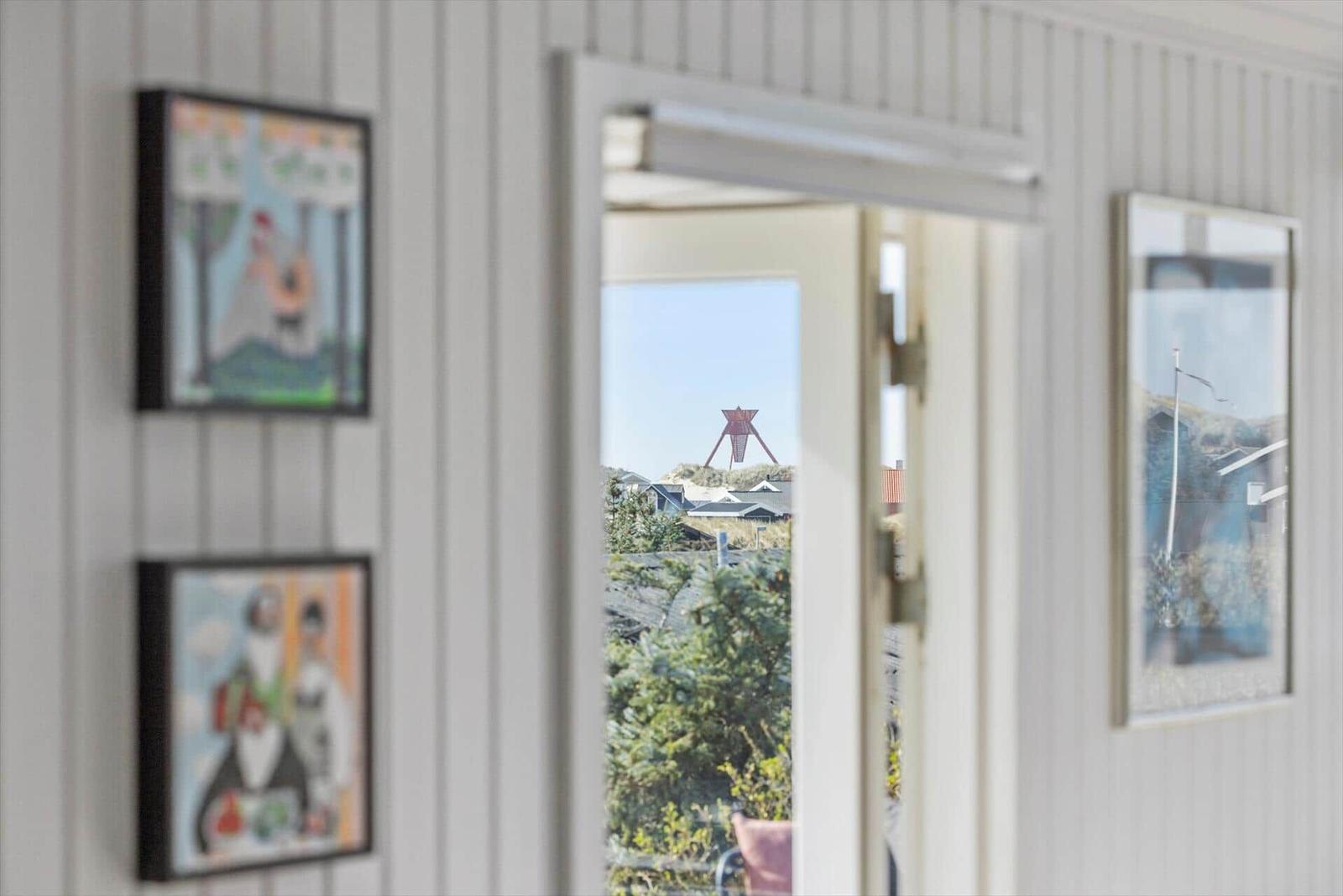 Durch die Tür ist ein Blick auf einen roten Turm und grüne Pflanzen möglich.
