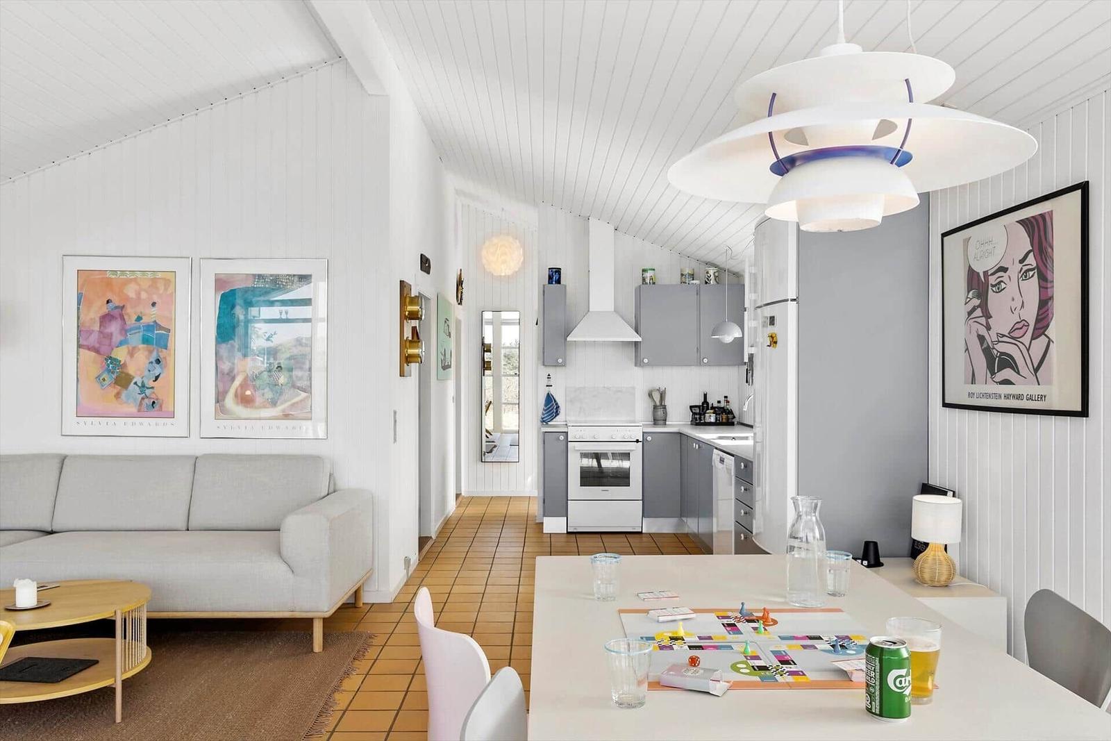 Wohn- und Küchenbereich mit Sofa, Essplatz und moderner Beleuchtung.