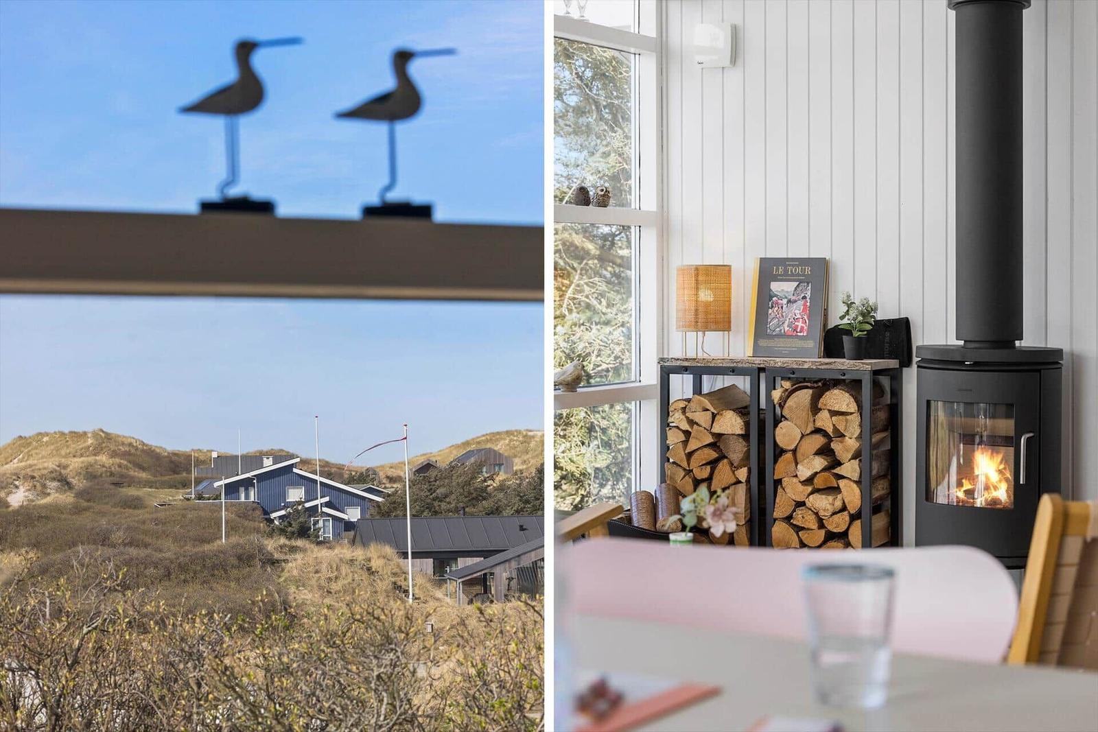 Vom Fenster aus Blick auf Dünen und Häuser. Im Innenraum steht ein Kamin mit Holzstapel.