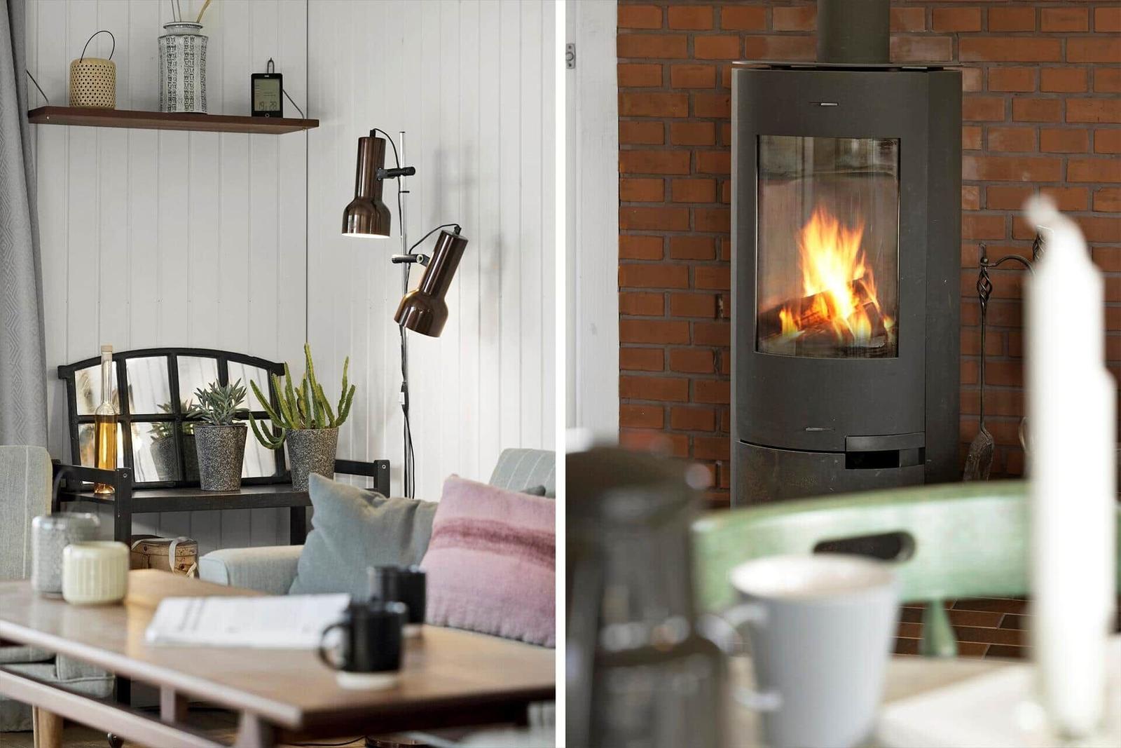 Wohnzimmer mit Kamin und Sofa. Holztisch, Pflanzen und Beleuchtung.