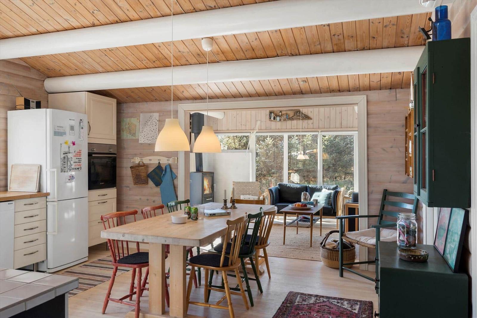 Küche mit Esstisch, Wohnbereich mit Sofa und Kamin.
