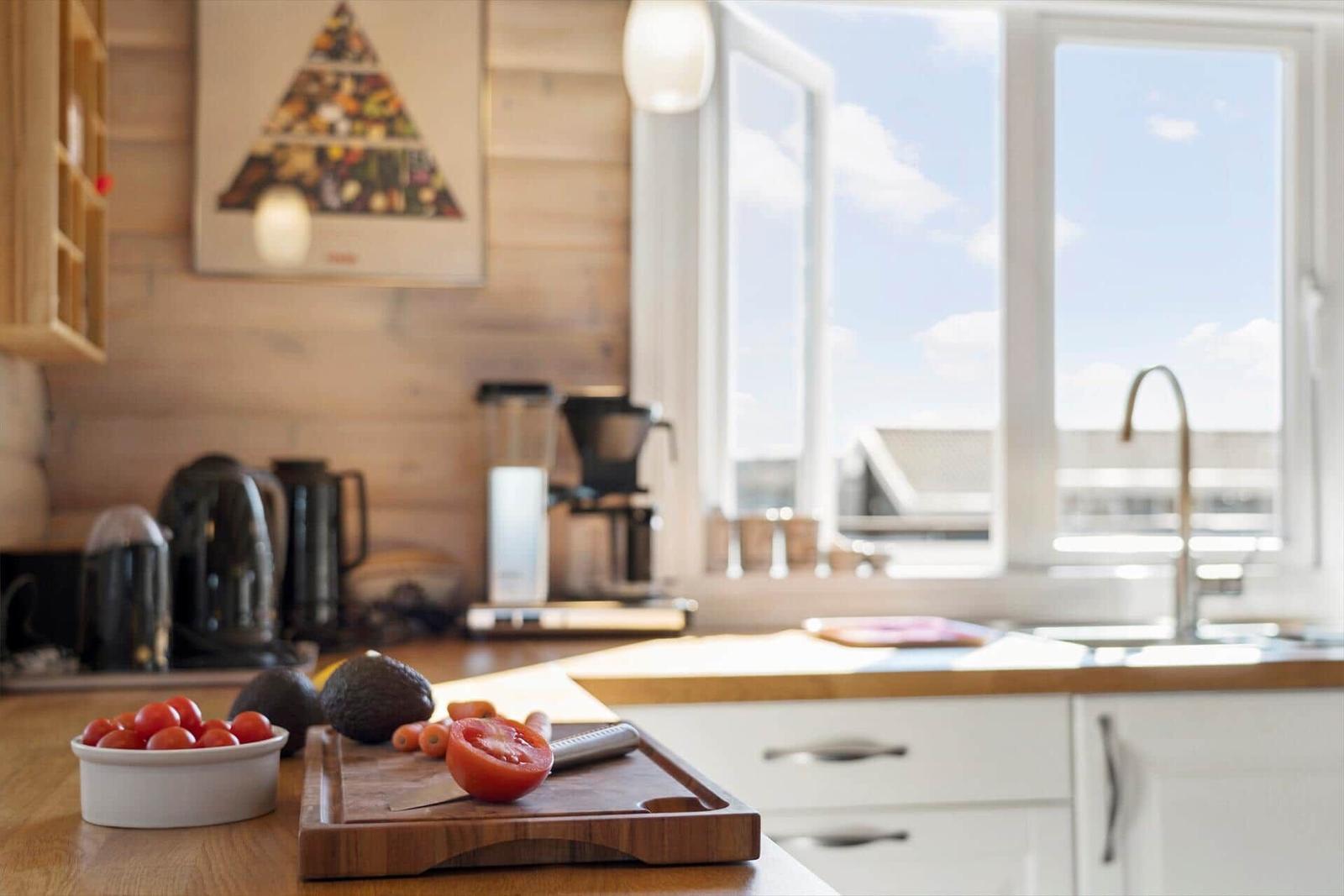 Küche mit Holzwänden, Arbeitsfläche und Fensterblick.