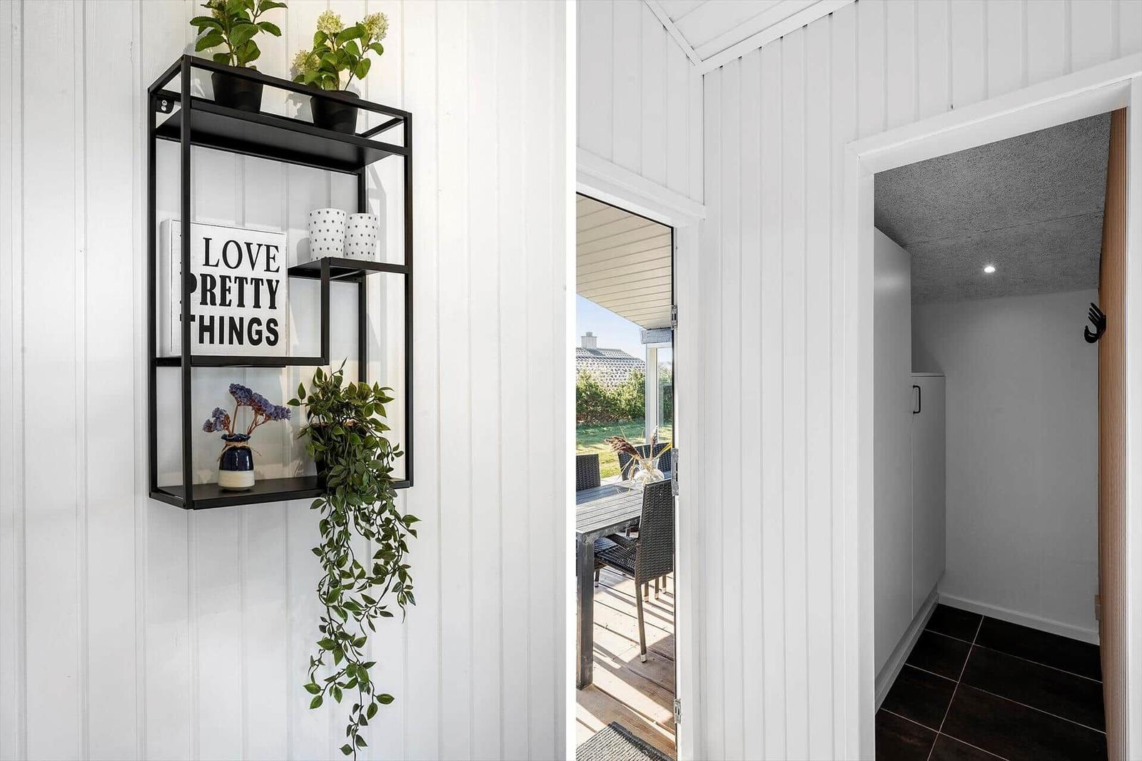 Wall shelf with plants and decor, view of terrace with table and chairs.