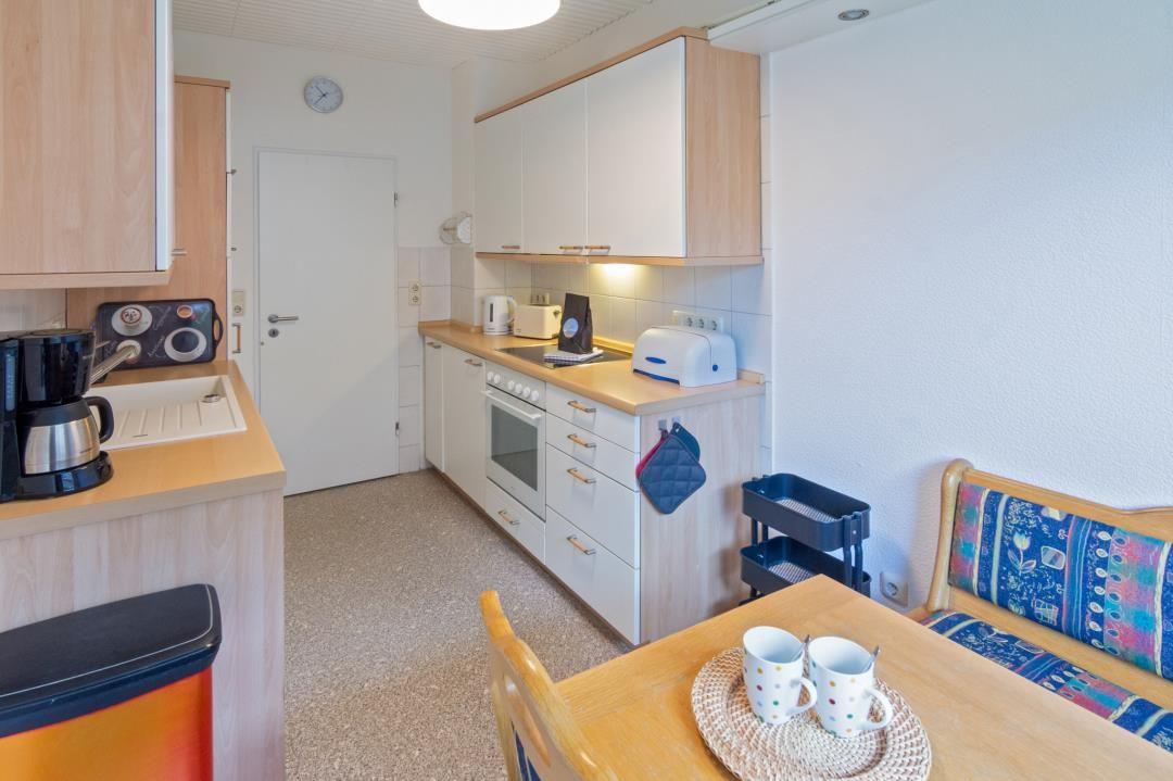 Küche mit Essbereich, Küchenzeile, Tisch und Stühle.