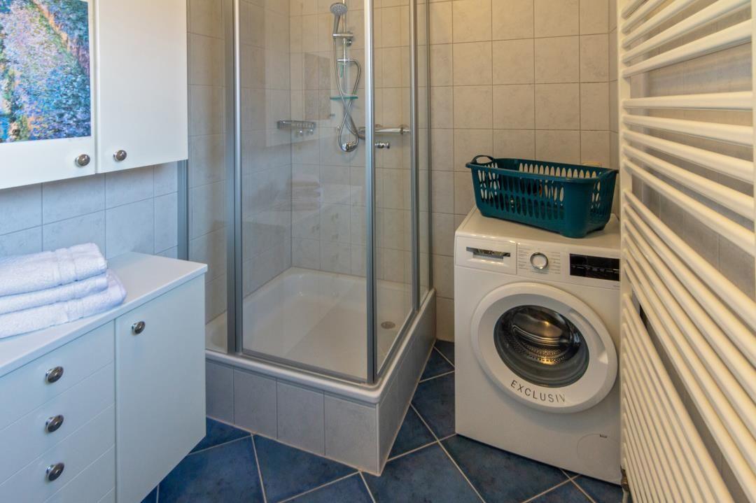 Bad mit Dusche, Waschmaschine und Handtuchständer