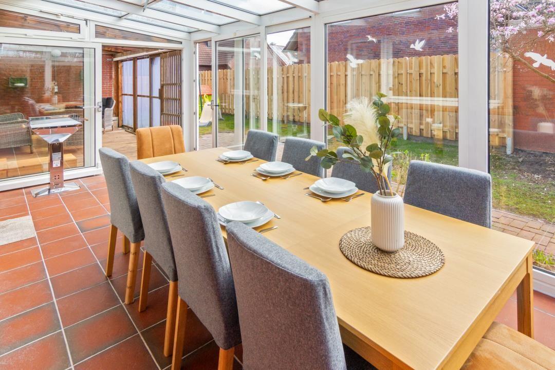 Essbereich mit Tisch und Stühlen, Terrasse und Gartenansicht.