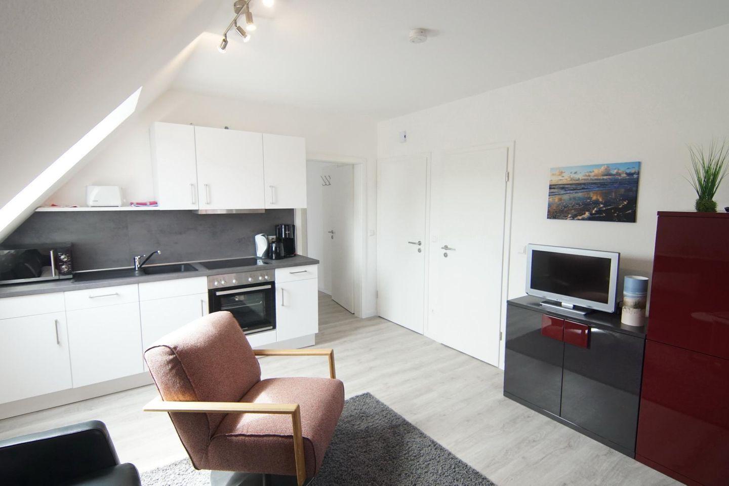 Wohnung mit Küche, Sitzgelegenheit und Fernseher